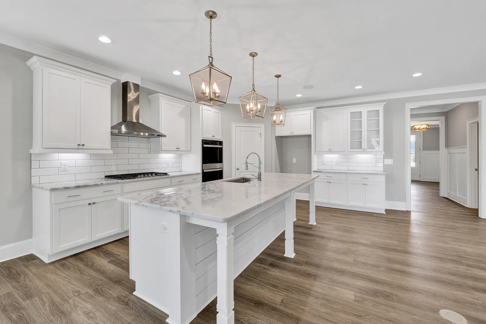 Bright white chef's kitchen with marble island
