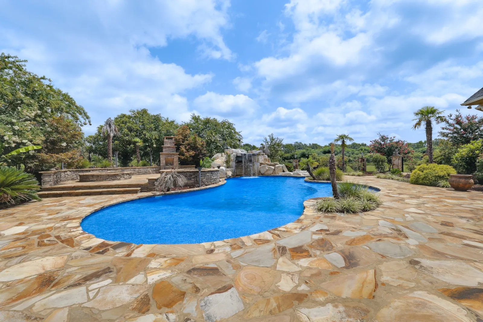 Resort-style pool with waterfall and stone deck